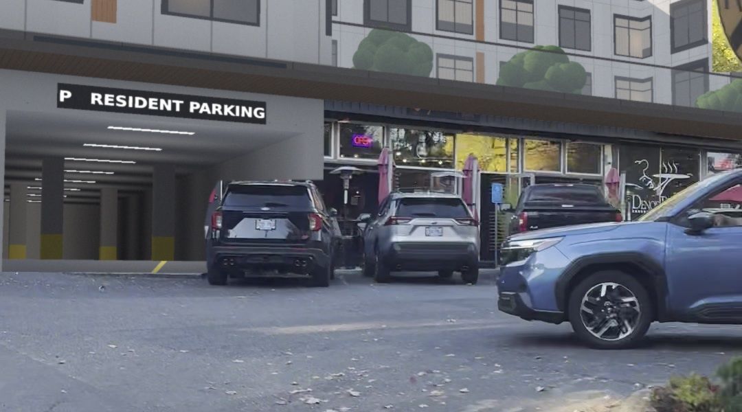 Close view of the resident parking entrance beside the restaurants, with a lit sign and ceiling lights inside