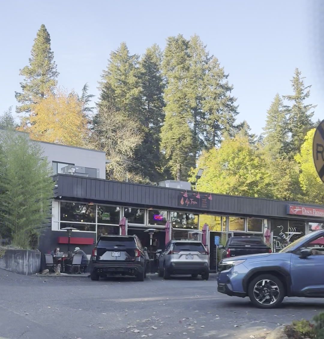 West Bay Center today: a one-story retail strip with restaurants, seen from the parking lot